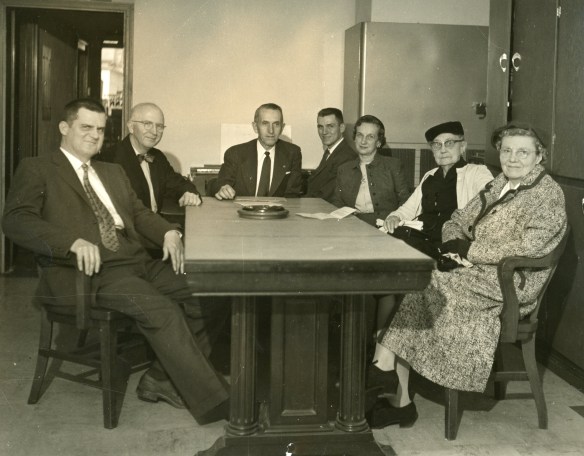 Group with J.G at Board Table sixties era